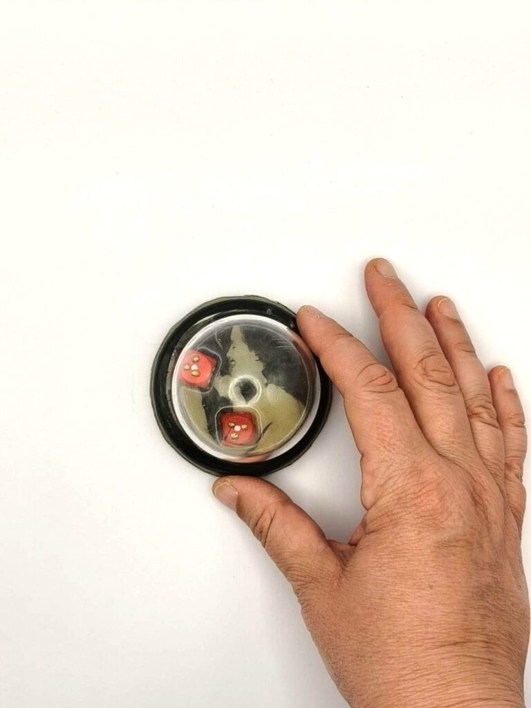 Dados — shown in hand for scale